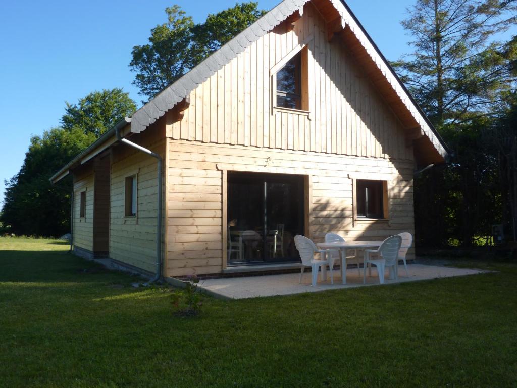 a small house with a table and chairs in the yard at Le Chalet de Seb in Ingouville