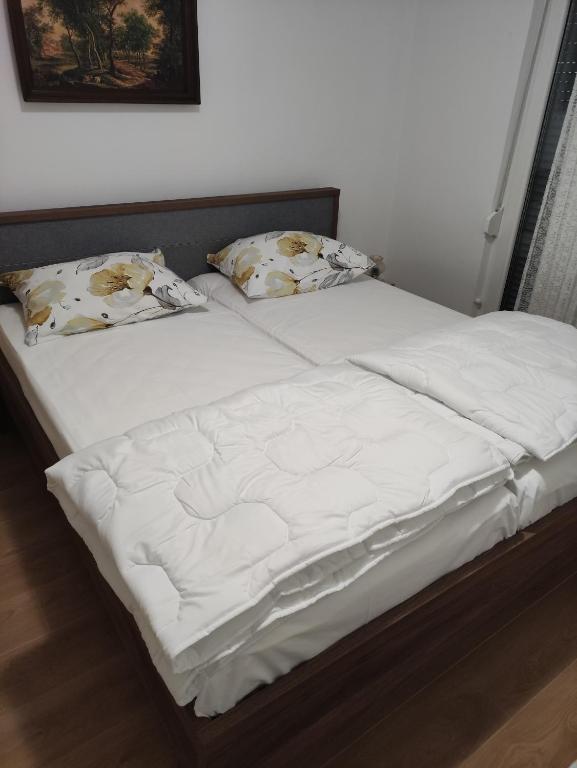 a large white bed with two pillows on it at Dragiv 2 Brdo48 selce in Selce