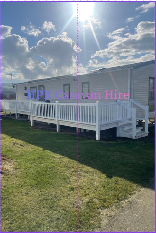a picture of a house with the sun in the sky at 3 bedroom, 2 bathroom caravan Presthaven Beach Resort in Talacre