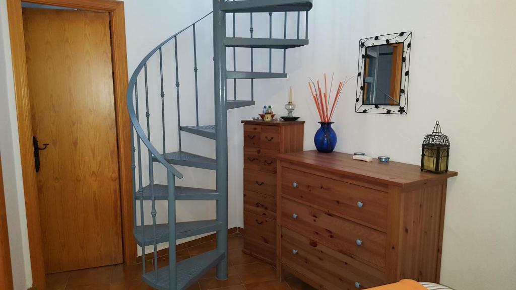 a blue spiral staircase next to a dresser and a mirror at Holiday home La Atalaya de Vejer in Vejer de la Frontera