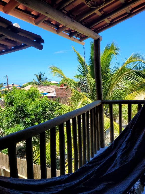 a hammock on a balcony with a palm tree at Vila Mukaú in Porto Seguro