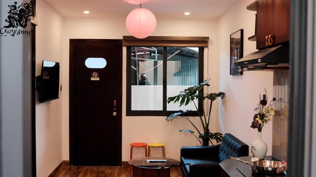 a living room with a black door and a table at CozyhomeDaLat in Khu Chi Lăng