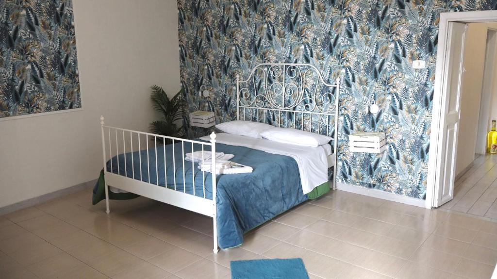 a bedroom with a bed with a blue patterned wall at ENGI CASA VACANZE in Naples