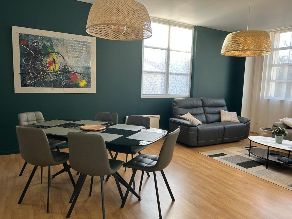 a living room with a table and chairs and a couch at Appartement spacieux avec parking privé in Chalons en Champagne