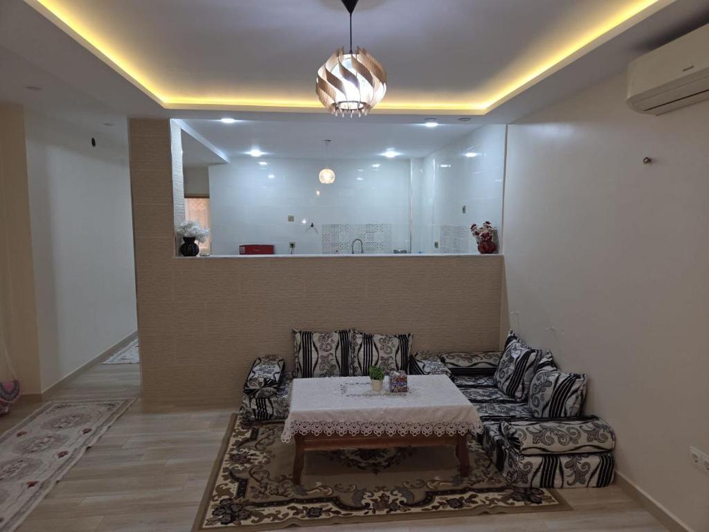 a living room with a table and a couch at Appartement indépendant de villa in Tipaza