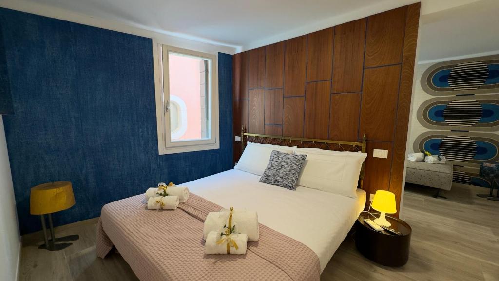 a bedroom with a large bed with two stuffed animals on it at Cà De La Corona EXPERIENCE in Chioggia