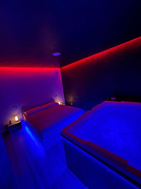 two beds in a room with red and blue lights at Fifty shades in Bisaccia