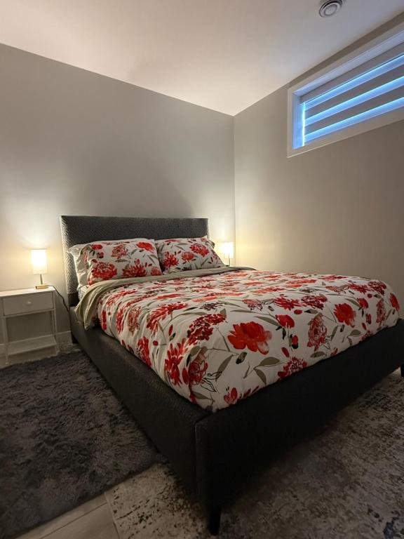a bedroom with a bed with a red and white comforter at Slice Of Paradise in Calgary