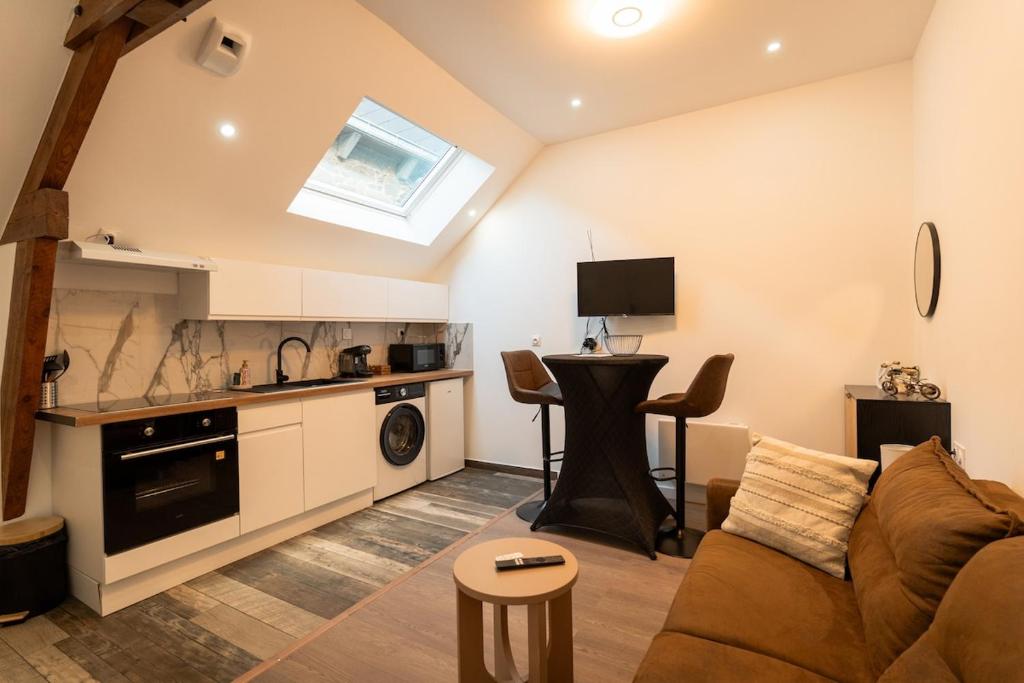 a living room with a couch and a kitchen at Yassam -Le Studio 301 in Saint-Brieuc
