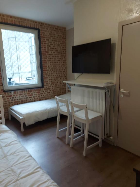una camera da letto con un letto e una scrivania con una TV di Deurne ad Anversa