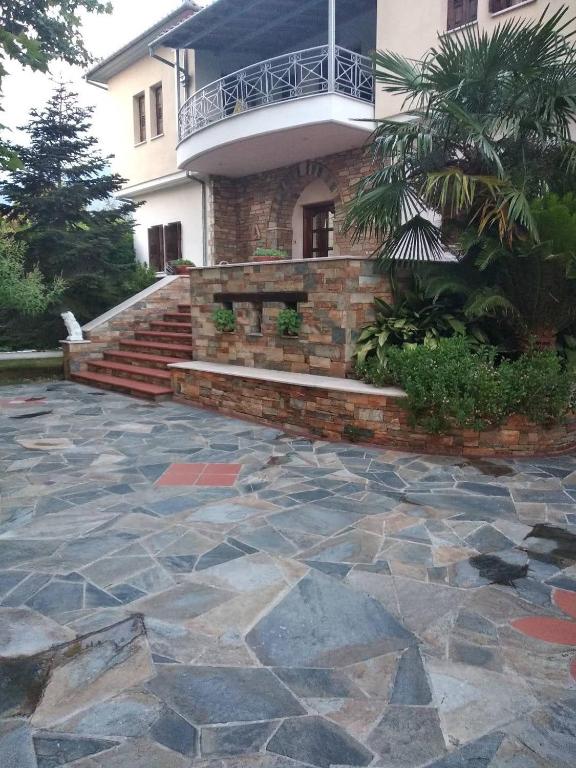 a house with a stone patio in front of a building at Villa Evi in Volos