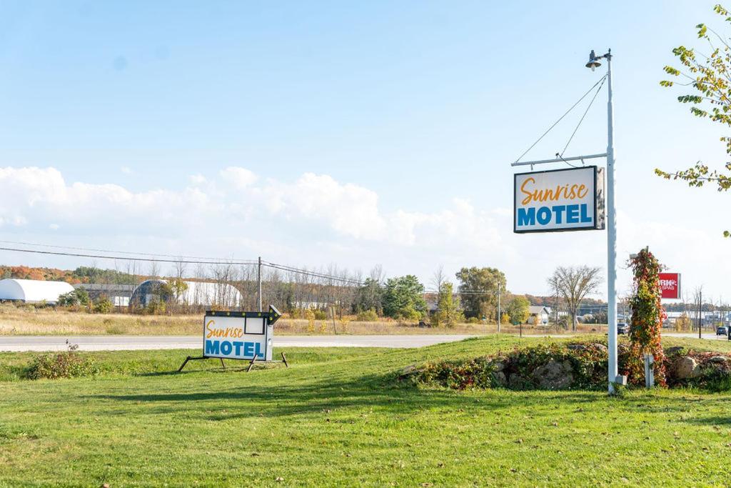 a sign for a motel on the side of a road at Sunrise Motel in Owen Sound