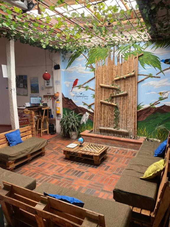 a room with chairs and a wall with a mural at ADVENTURE Hostel in San Gil