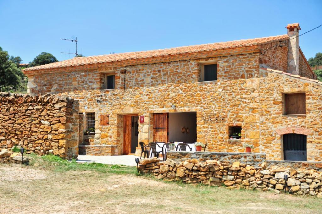 a stone house with a stone wall in front of it at Masia Campos Culla in Culla
