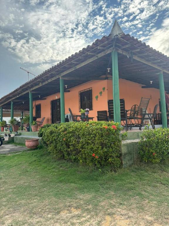 a house with chairs and tables and a roof at Casa Tradição do Catu in Aquiraz