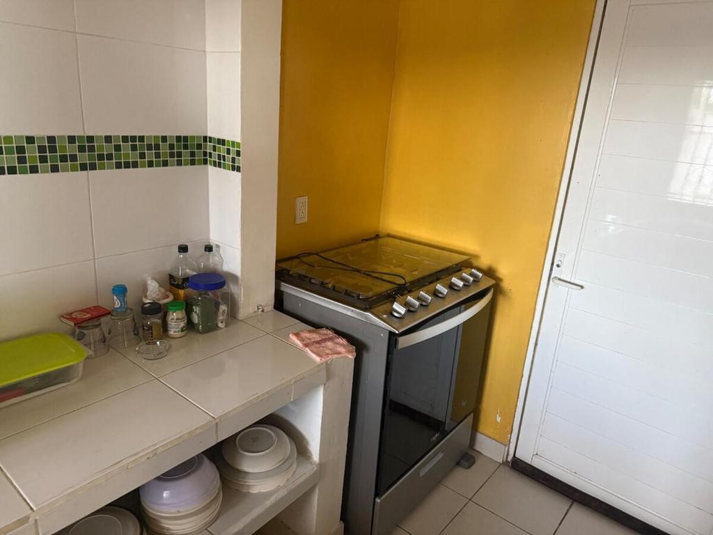 a kitchen with a stove and a counter with dishes at Casa Pelícanos playa de chachalacas in Ursulo Galván