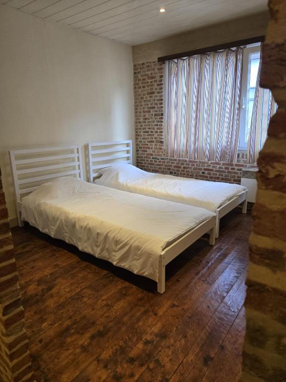 two twin beds in a room with a window at Schijnpoort in Antwerp