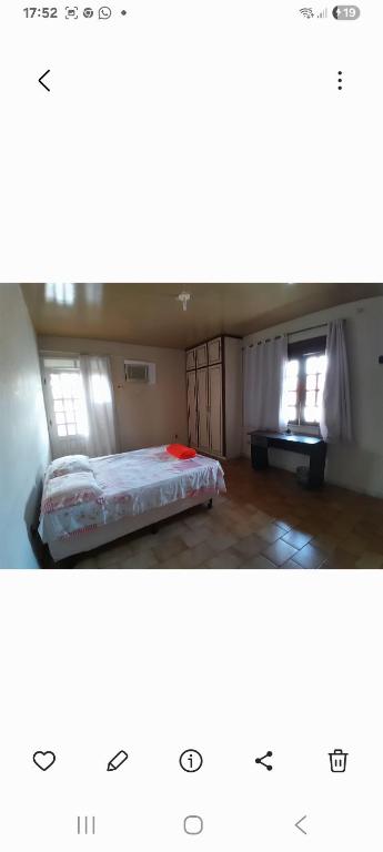 a bedroom with a bed and two windows at Alto Astral in Fortaleza