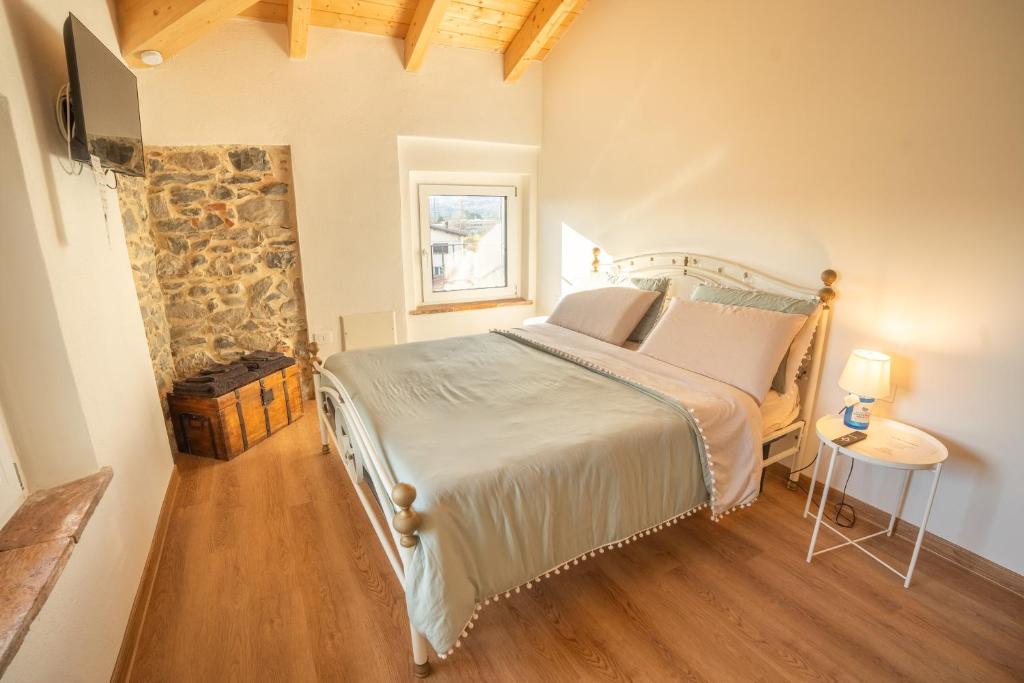 ein Schlafzimmer mit einem Bett und einer Steinwand in der Unterkunft Cà Bianca in Erba