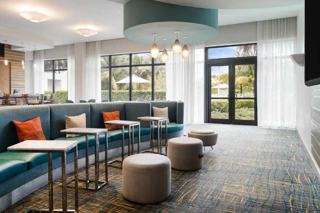 a lobby with a blue couch and stools at EVEN Hotel Miami - Airport by IHG in Miami