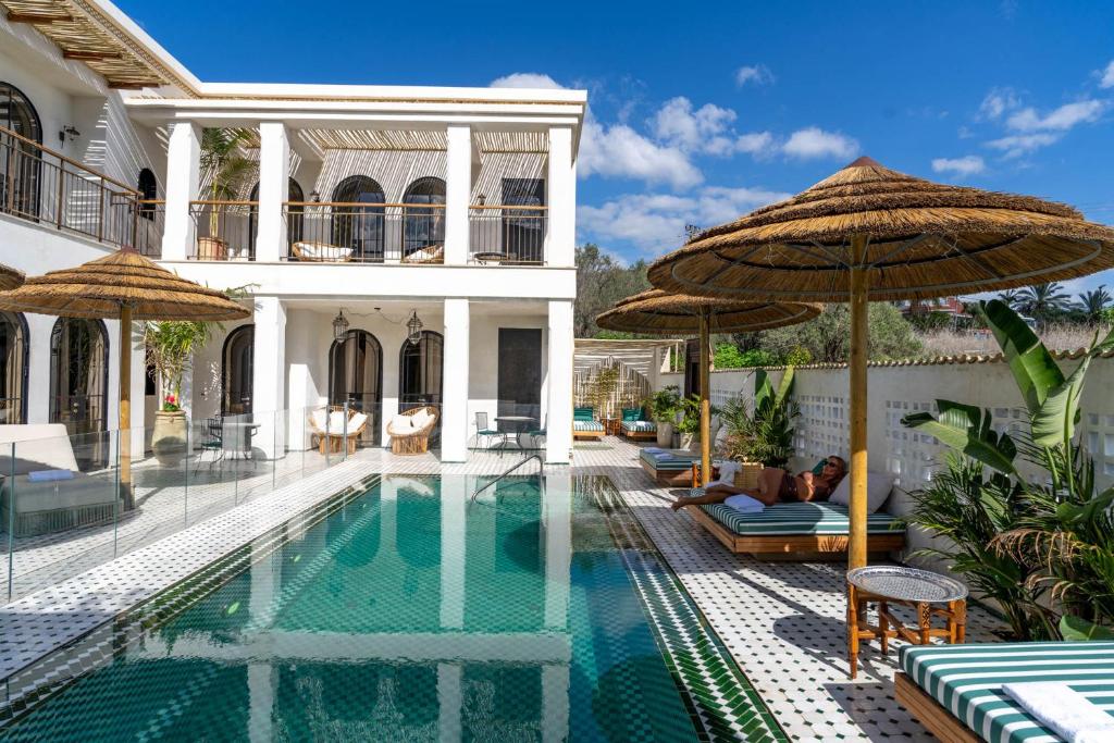 a villa with a swimming pool with umbrellas at Villa Riad- וילה ריאד מתחם נופש יוקרתי in Migdal