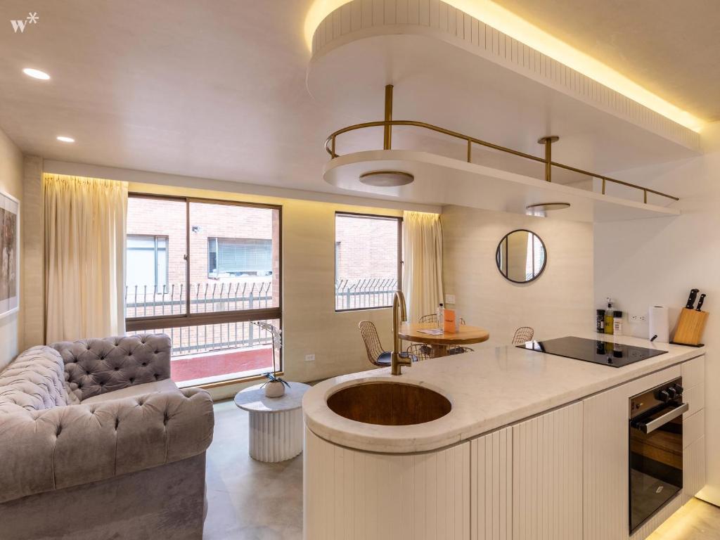 a kitchen with a sink and a living room at Palace by Wynwood House in Bogotá