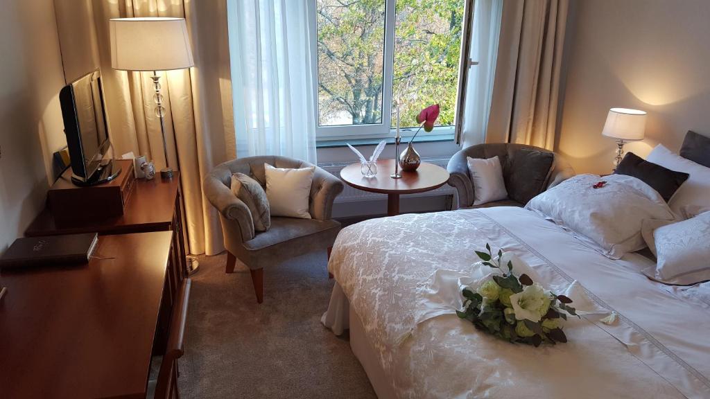 um quarto de hotel com uma cama, uma mesa e uma janela em Solitaire em Poděbrady