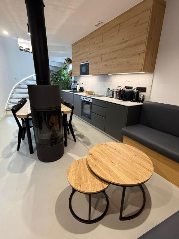 a living room with two tables and a stove at Adiva A Zapataría in Puentedeume