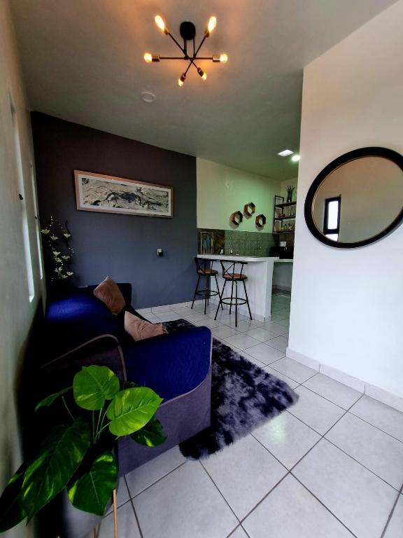 a living room with a blue couch and a mirror at Vista Sumidero in Tuxtla Gutiérrez