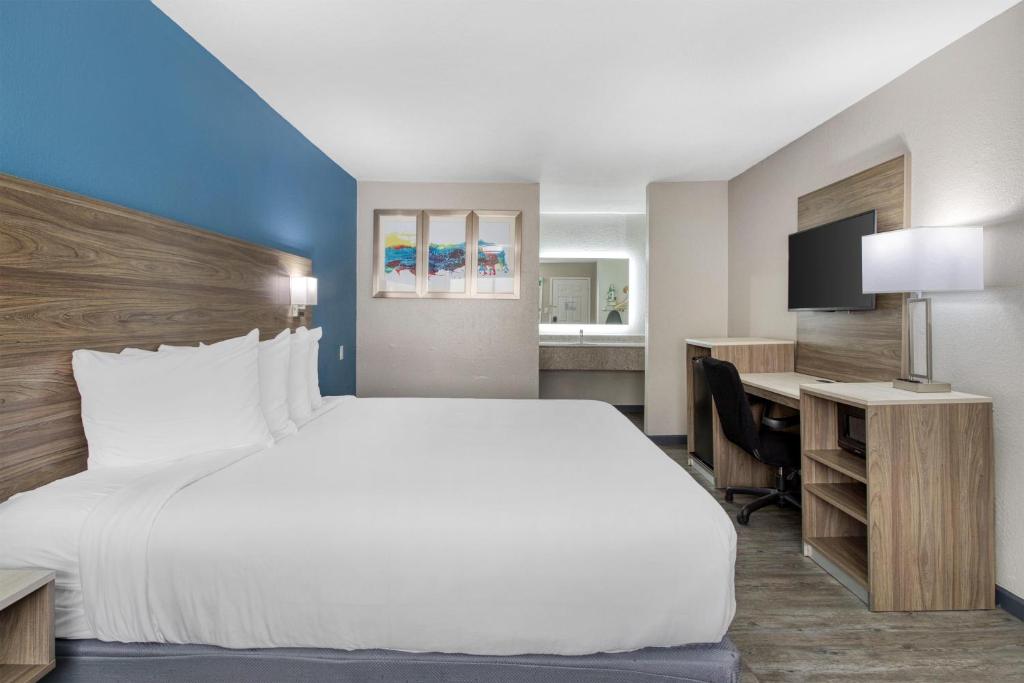 a hotel room with a large bed and a desk at SureStay Hotel by Best Western Spring North Houston in Spring