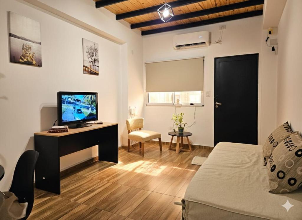 a living room with a bed and a tv and a desk at Departamentos A&B in Resistencia