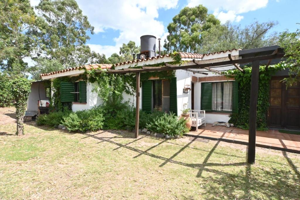 a small white house with green shutters at Casa Amaranta in La Cumbre