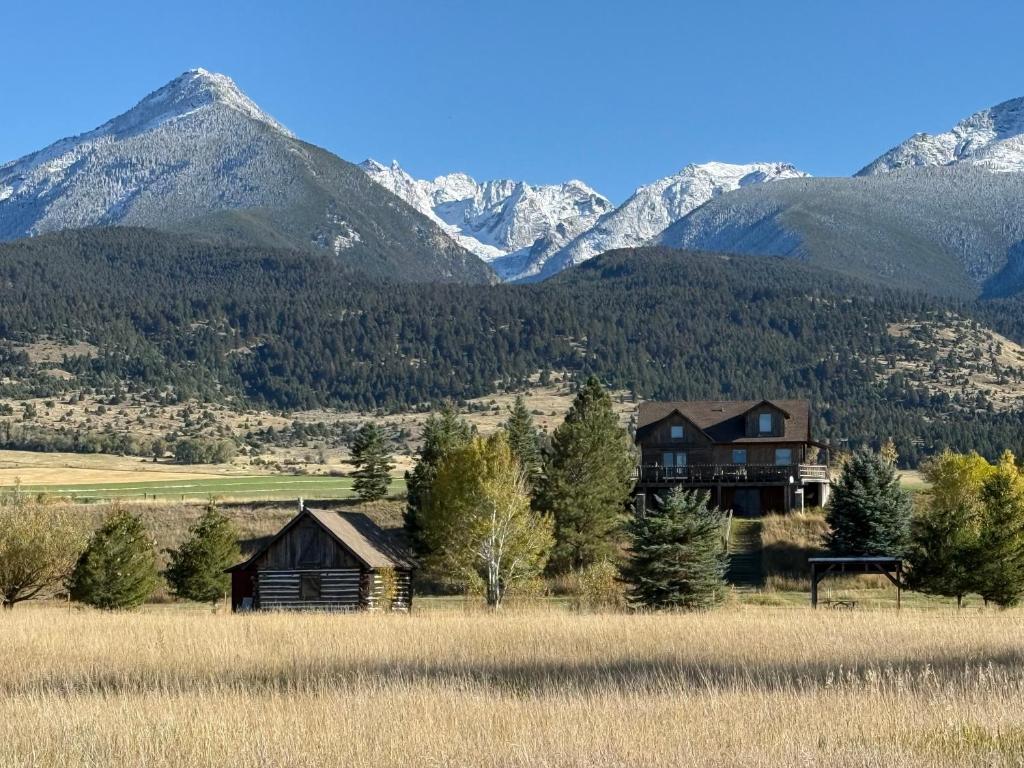 a house in a field with mountains in the background at Yellowstone House in Livingston