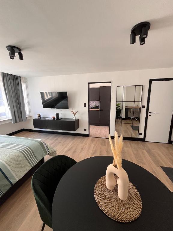 a bedroom with a bed and a table in a room at Studio moderne et confort - Guillemins in Liège