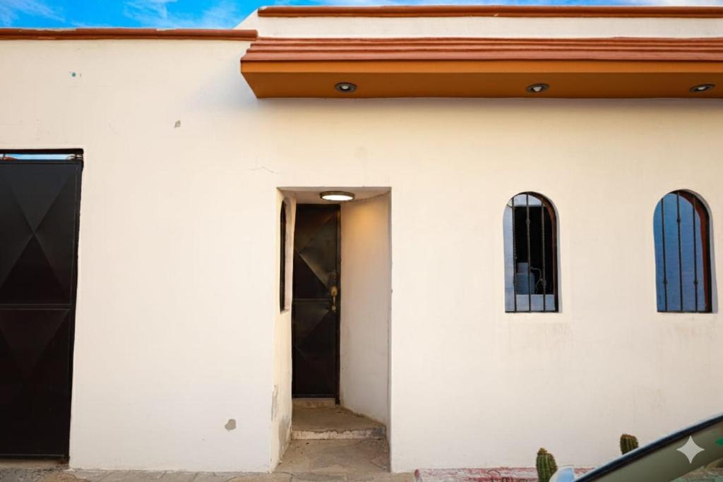a white building with a door and a window at Entire accommodation in Bahia de la Paz in La Paz