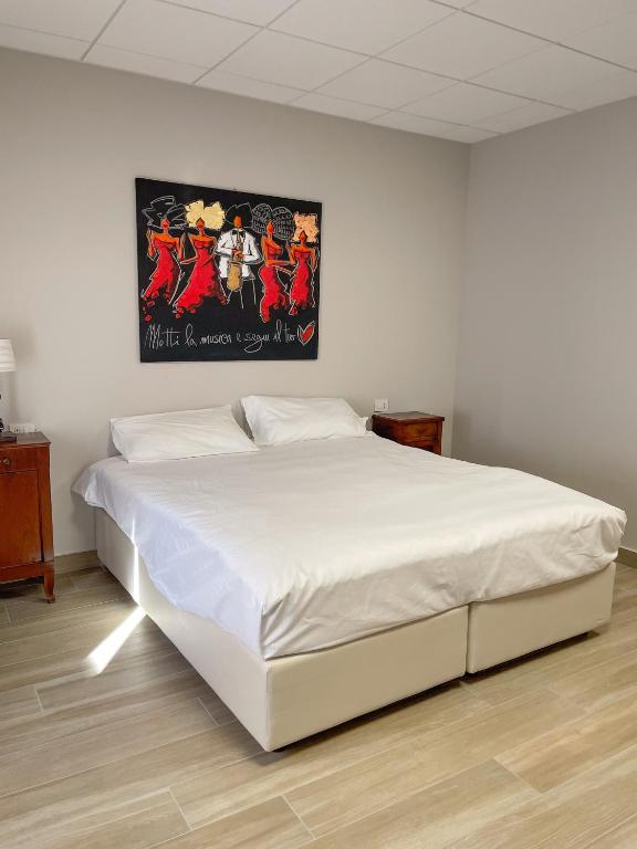 a white bed in a bedroom with a picture on the wall at Mama Lidia in Creazzo
