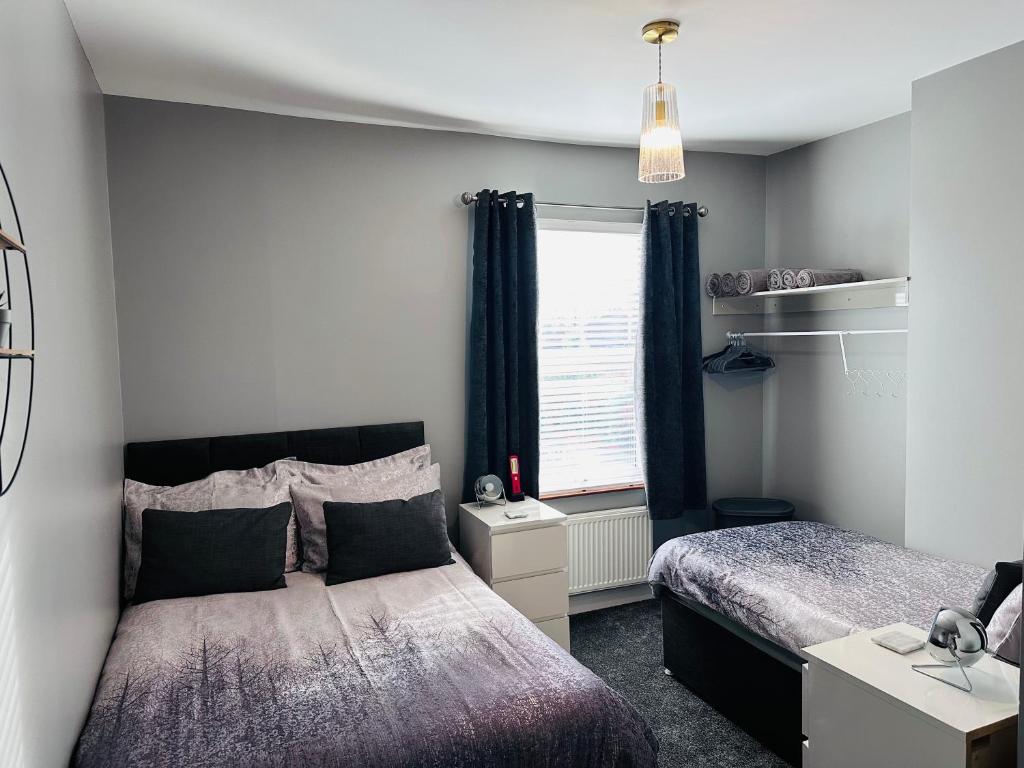 a bedroom with two beds and a window at House in Hemingfield, Ideal for Contractors and Long Stays in Wombwell