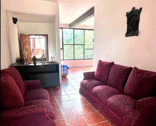 a living room with a couch and a mirror at La Enamorada Cabañas & Resort in Zacatlán