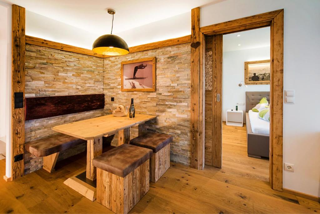 a dining room with a wooden table and benches at Royal Waldfeld in Mayrhofen