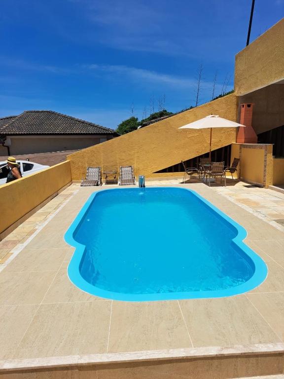 a large blue swimming pool on a patio at Triplex com Piscina no Peró - Perto da Praia in Cabo Frio