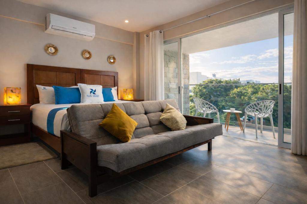 a bedroom with a bed and a couch at Blue Veleta in Tulum