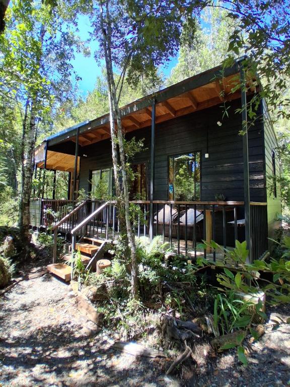 a cabin in the woods with a large deck at Espacio Bosque La Quemada in Puerto Varas