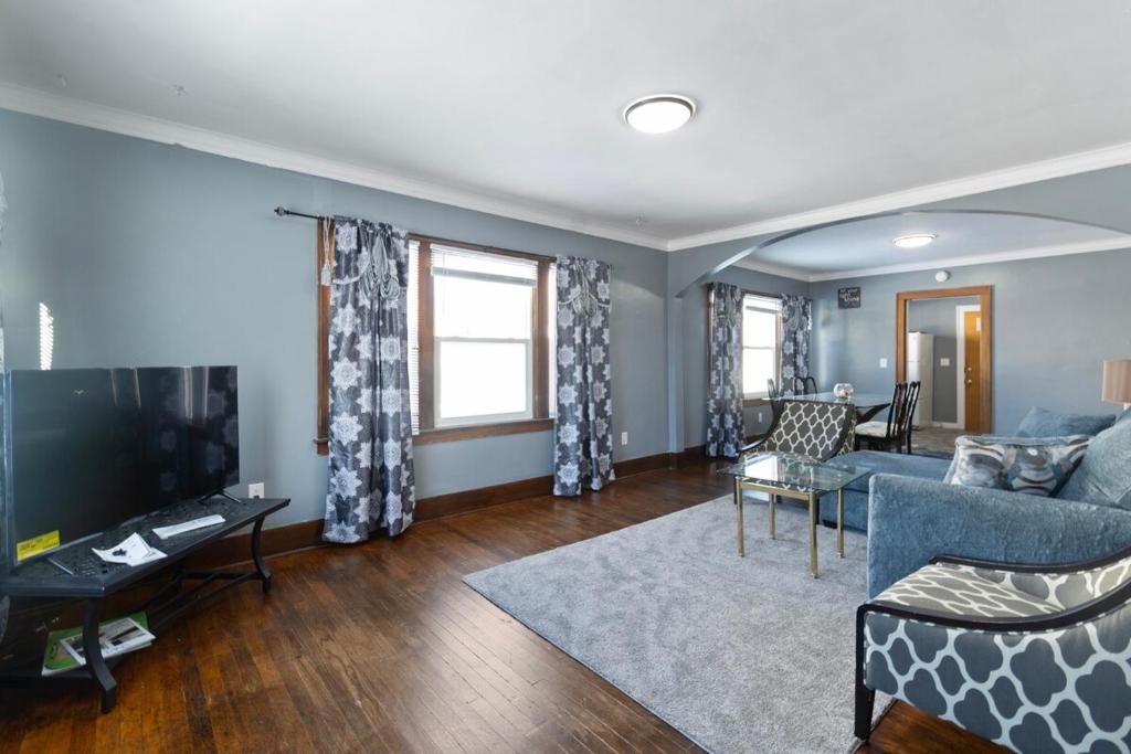 a living room with a couch and a tv at College Duplex in Grand Rapids