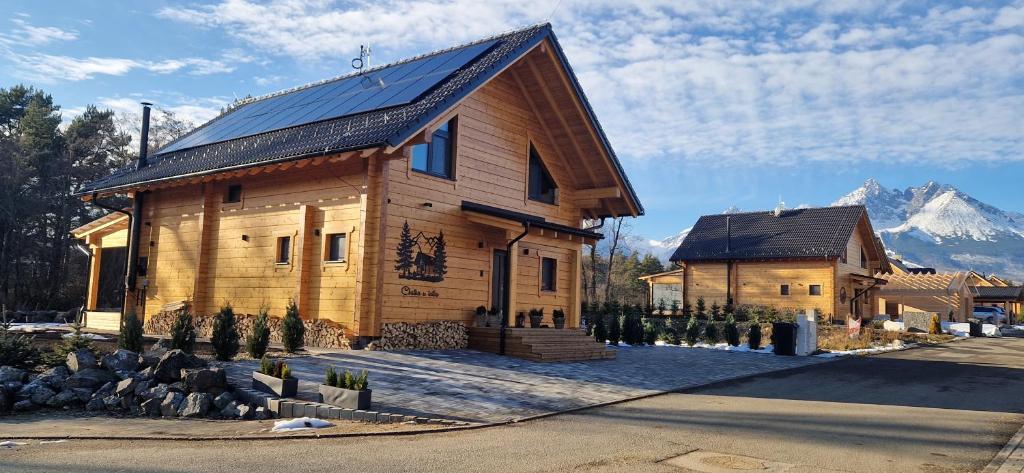 a large wooden house with a mountain in the background at Chatka u tatka in Vysoké Tatry