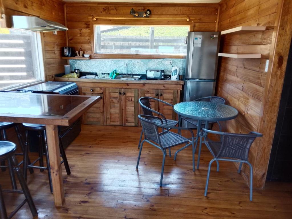 a kitchen with a table and chairs and a refrigerator at Cabaña tree in Boca Pupuya