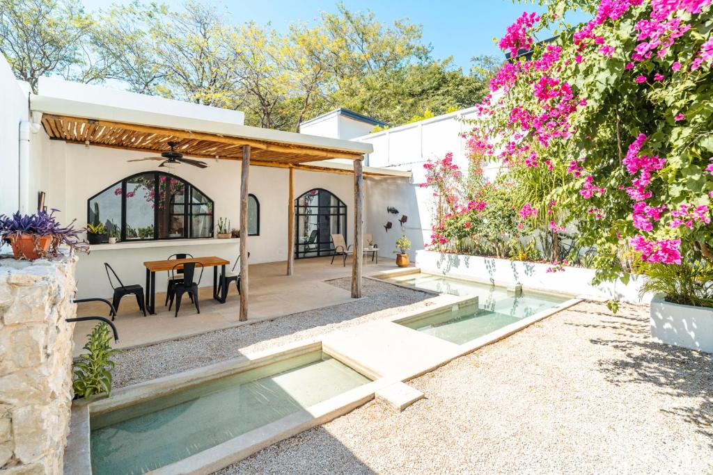 a backyard with a pool and a table and flowers at Las Guapas Villas Tamarindo in Tamarindo