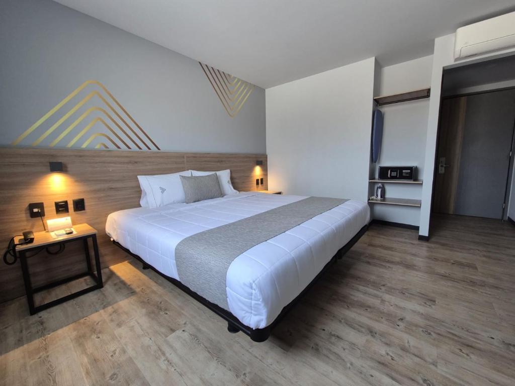 a bedroom with a large white bed and a table at Avanta Hotel & Villas Querétaro in Santa Rosa de Jáuregui