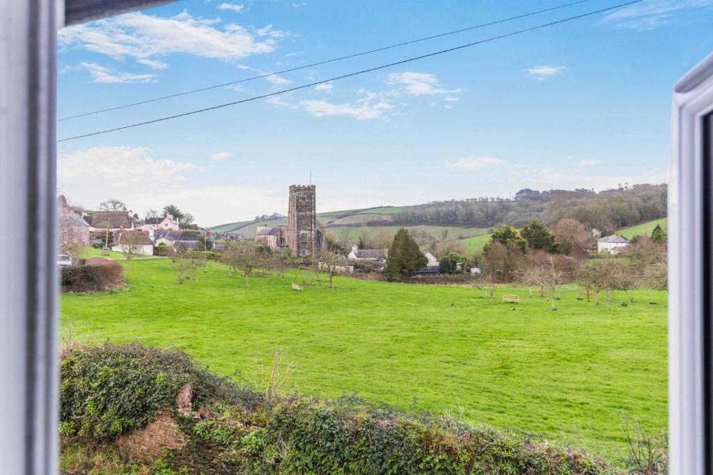 a view of a field with a church in the distance at 4 Bed in Stokenham oc-i34021 in Stokenham