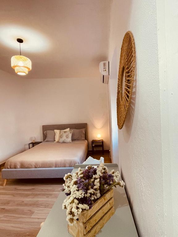 a bedroom with a bed and a table with flowers at Janelas do Governador in Elvas