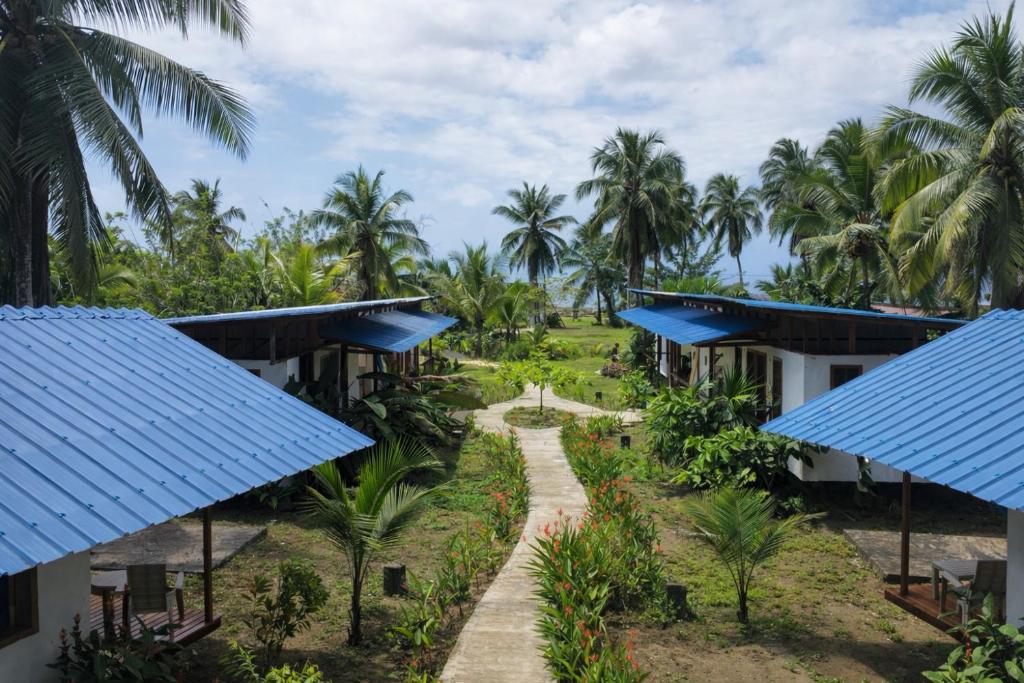 a view of the courtyard of a resort with blue roofs at Pacific Waves Hostel & Surf in El Valle